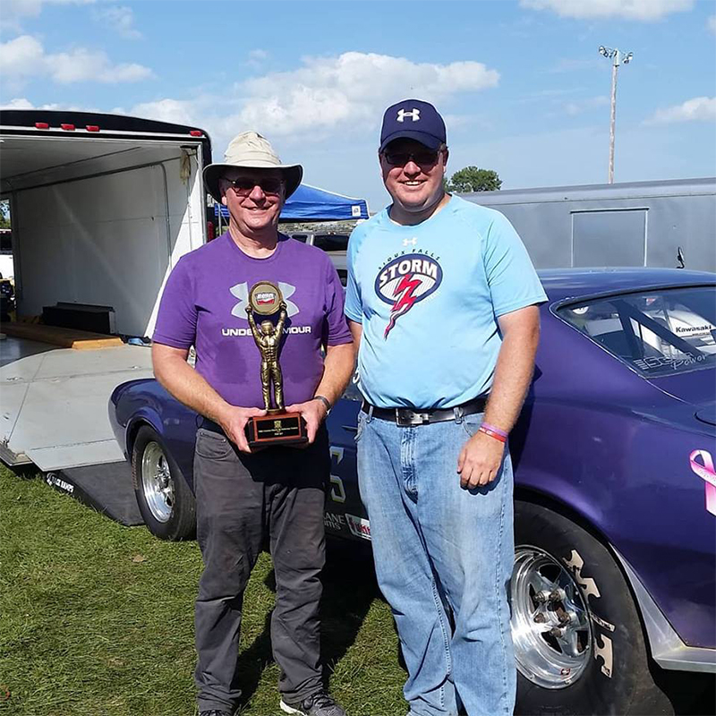 Adam Lamprecht and his dad with a drag racing trophy.